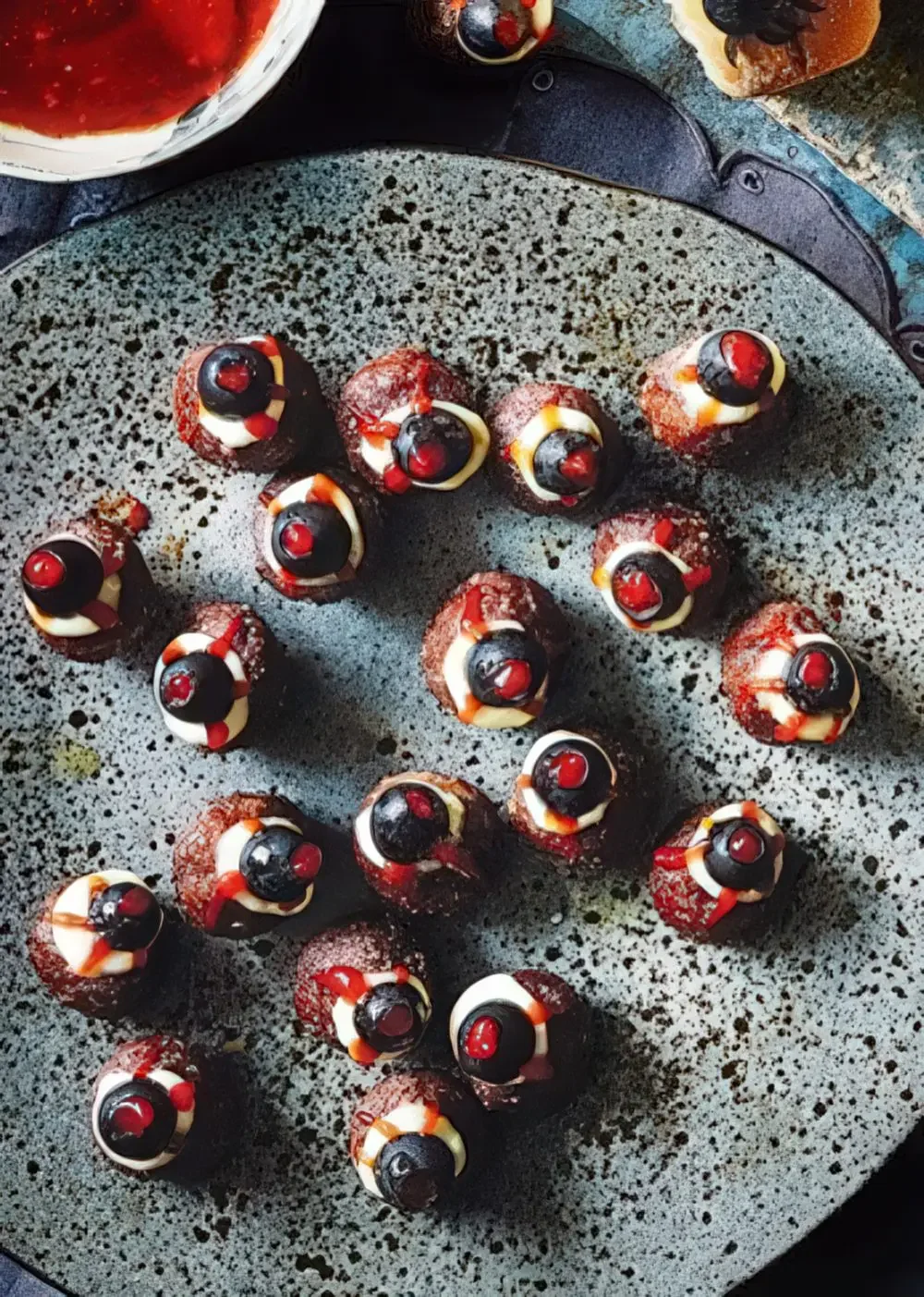 Zeytin ve peynirle süslenmiş köfte gözler, Cadılar Bayramı için harika bir yiyecek fikri.