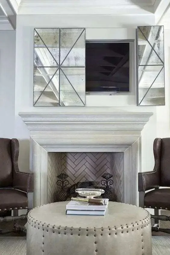 Tuğla kaplı şömine ve eski aynalı panellerle gizlenmiş TV, vintage nötr bir oturma odasında harika bir fikir.
