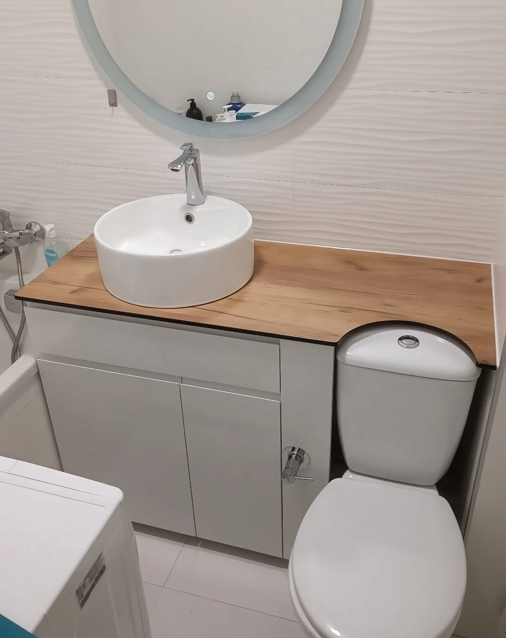 Fonksiyonel tasarımlı bu banyoda, tezgah üstü lavabo ve altında gizli depolama dolabı ile küçük daire banyolarına şık ve pratik çözüm sunuluyor.