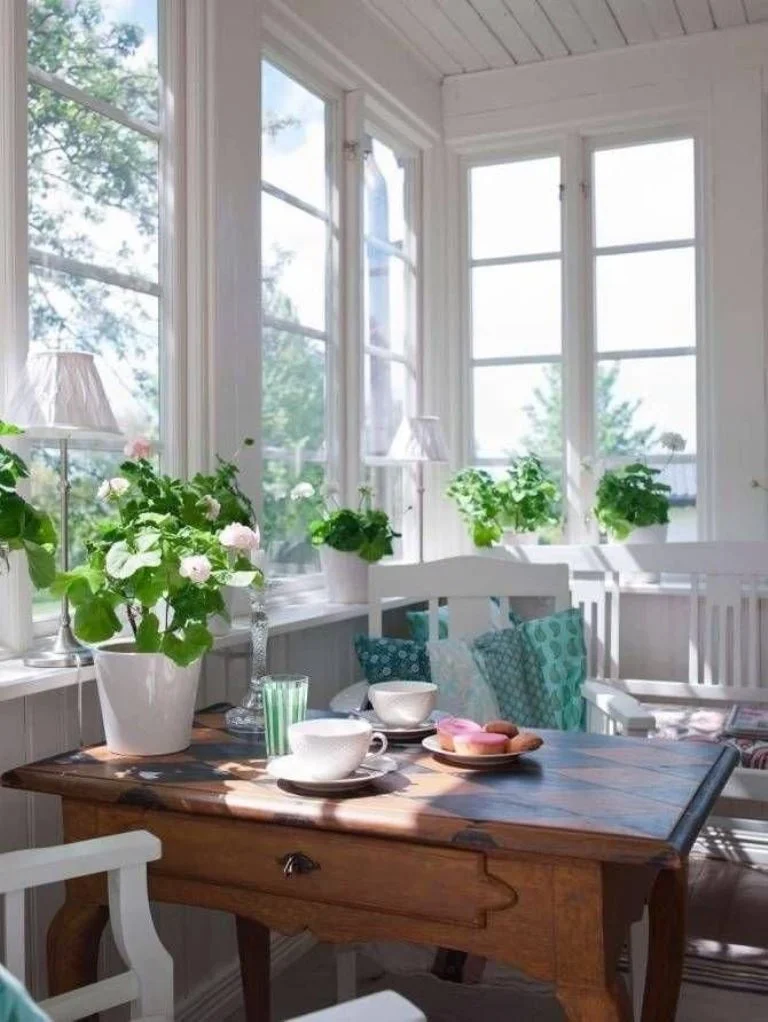 Bu balkon, güzel lambalar ve saksı bitkileri ile zarif bir vintage yemek odasına dönüştürülmüş.