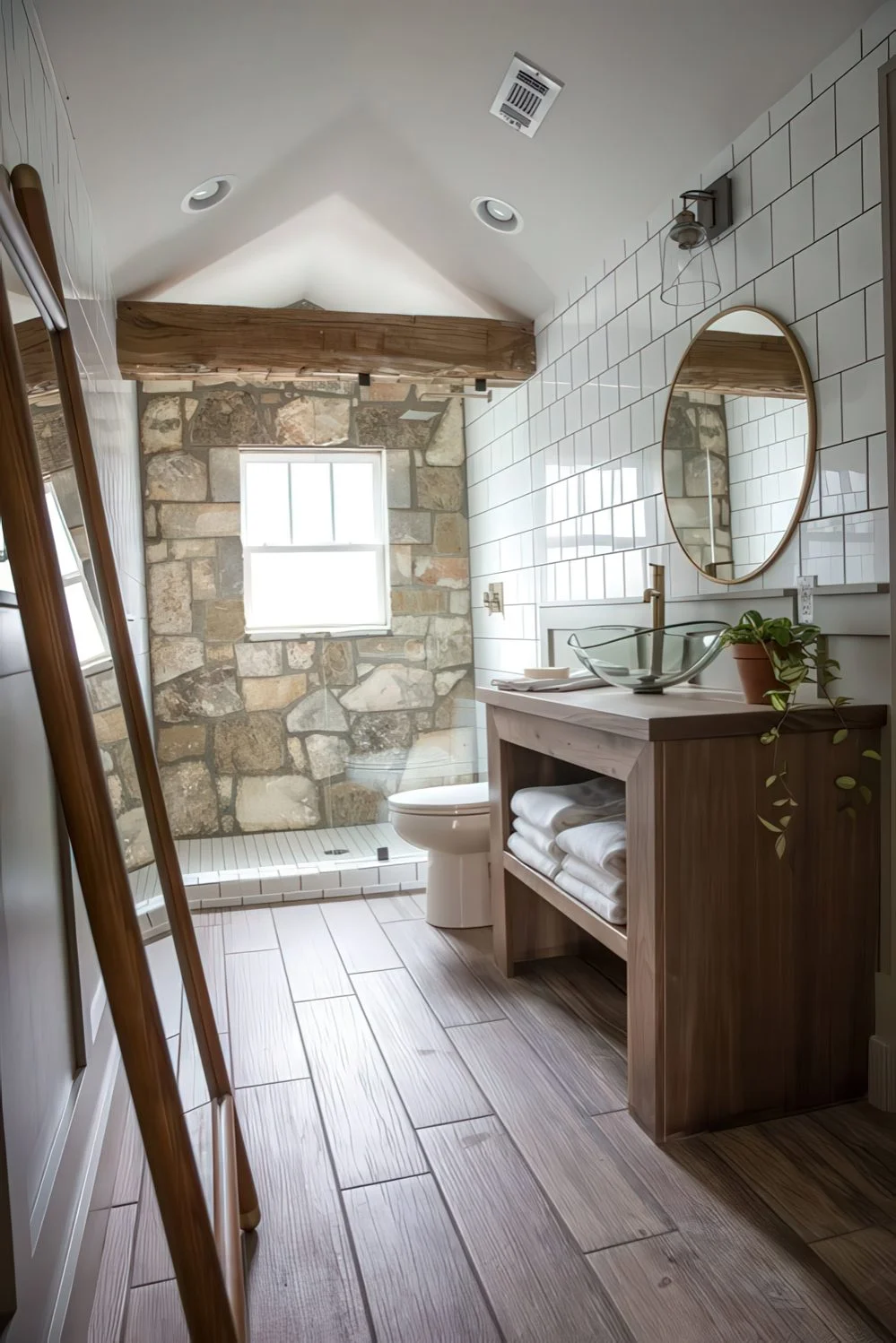 Ahşap kirişli, taş duvarlı, ahşap banyo dolaplı, aynalı ve beyaz fayanslı ahır banyosu.