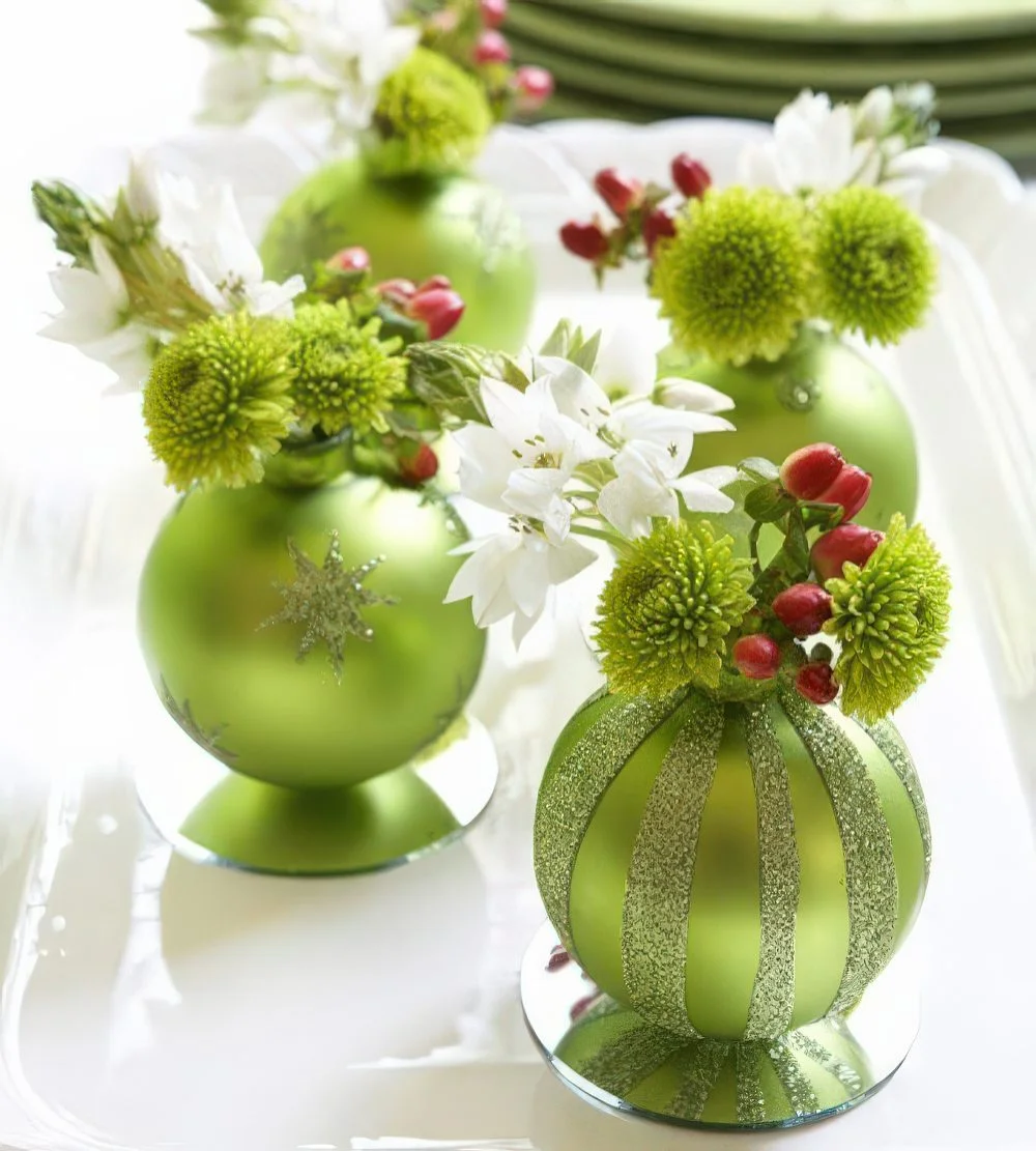 Çiçekler ve meyveler için mini vazo olarak kullanılan renkli yılbaşı süsleri, şenlikli masa düzeni için harika.