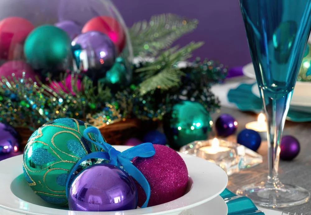 Renkli Noel süslerini kaselere ve kadeh örtülerine koyarak masa düzenine canlı ve eğlenceli bir hava katın.