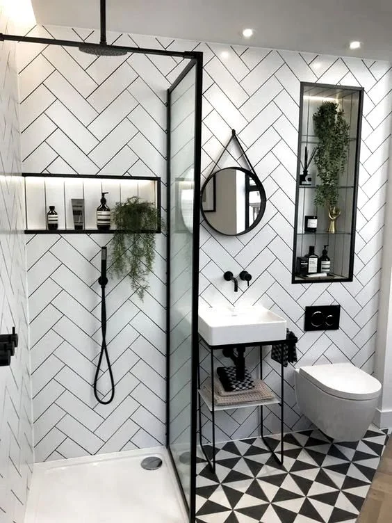 Kılçık fayans duvarlı, desenli zeminli çağdaş küçük banyo. Küçük lavabo ve cam bölmeli duş alanı içeriyor.