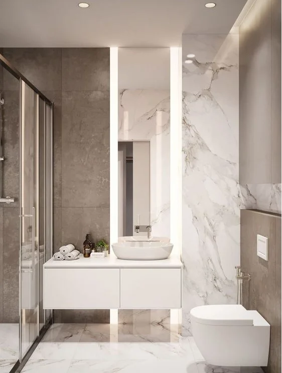 Mermer karolu küçük minimalist banyo, duş alanı, askılı lavabo ve ışıklı uzun ayna.