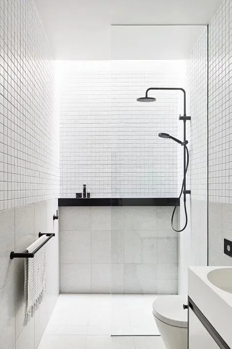 Beyaz küçük ve büyük karolar, siyah armatürler ve siyah-beyaz minimalist küçük banyo.