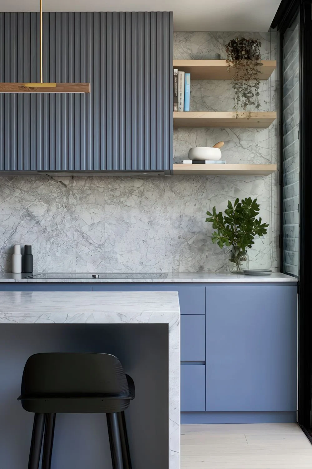 Gri taş sırtlık ve tezgahlar, saksı yeşillikleri ve altın dokunuşlarıyla minimalist mavi mutfak.