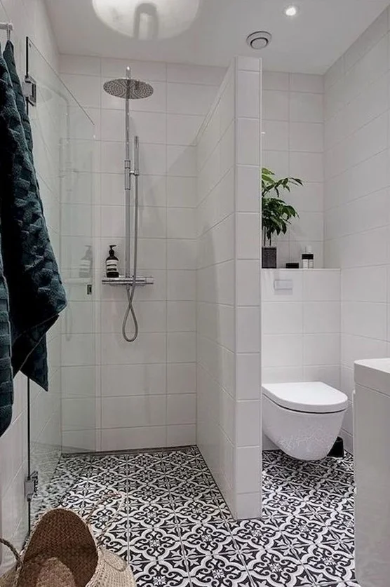 Çağdaş banyo; mozaik ve beyaz duvar karoları, saksı bitkisi ve depolama sepetiyle ferah bir atmosfer.