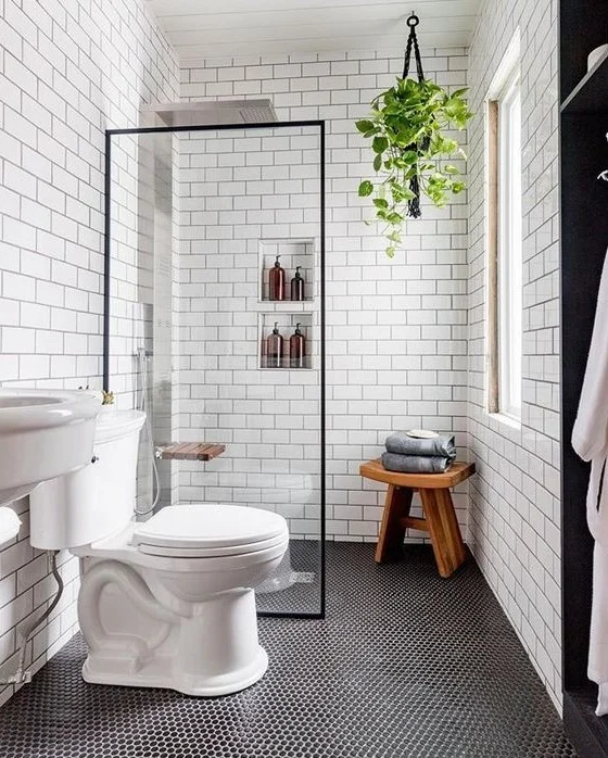Modern banyo; küçük mozaik ve metro karolar, gömme raflar, lavabo ve ahşap tabure ile fonksiyonel alan.