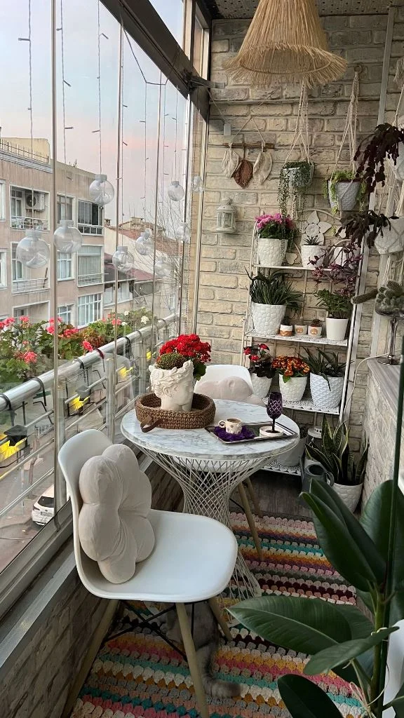 Dar balkon, renkli halılar, çok sayıda saksı bitkisi ve bohem dekorla cesur bir şekilde tasarlanmış.