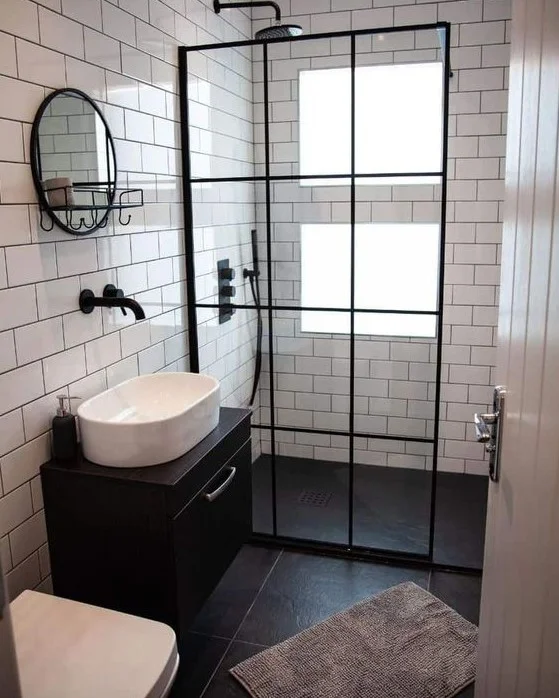 Siyah-beyaz kontrast karolar ve duşta pencere. Siyah raflı lavabo modern ve şık bir hava katıyor. Siyah detaylar tasarımı tamamlıyor.