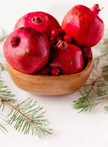 Nar ve turna yemişini ahşap kaseye koyarak hem sonbahar hem de Noel için uygun bir orta süs yapın.