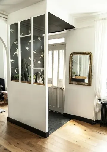 Ek yapı, baskılı duvar kağıdıyla vurgu yapılmış küçük bir giriş gibi, cam duvar ışığın içeri girmesini sağlıyor.