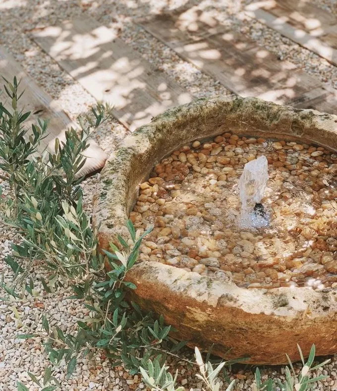 Eski taş kase modaya uygun çeşmeye dönüştürülmüş ve içi çakıllarla doldurulmuş.