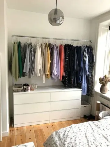 Küçük bu geçici dolap, minimal bir şifonyer ve geniş bir asma kıyafet rayını sergiliyor.
