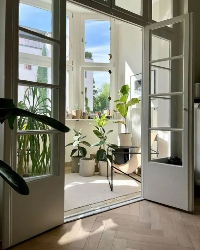 Nötr balkon, birçok saksı bitkisi, güneşin ve manzaranın keyfini çıkarabileceğiniz bir sandalyeye sahip.