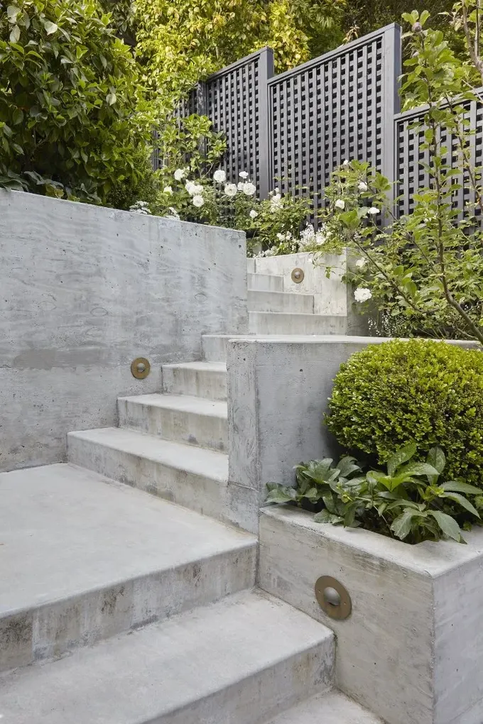 Bu minimalist katlı bahçe beton ve budamalardan oluşuyor, yeşillikler ve çiçekler betona yumuşaklık katıyor.
