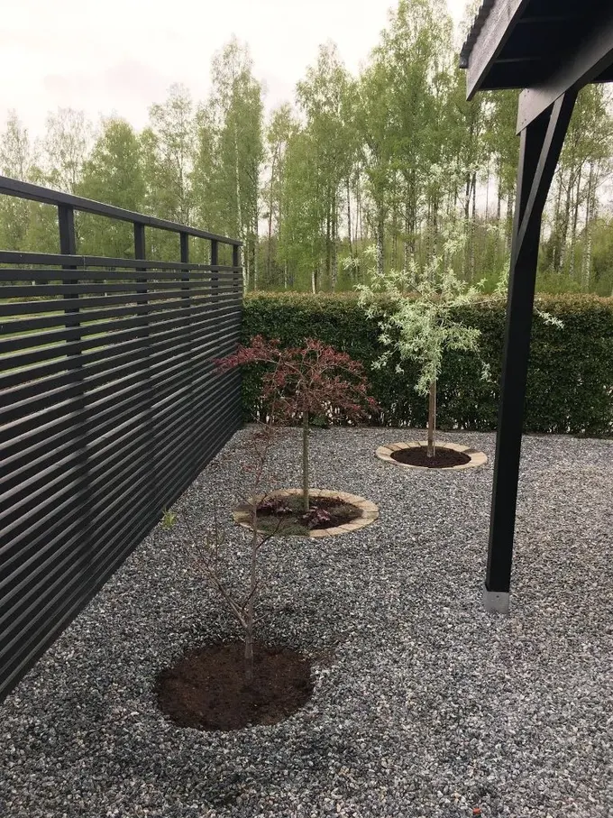 Siyah yatay çit ışık ve hava akışına izin verir, bahçeyi daha geniş hissettirir.