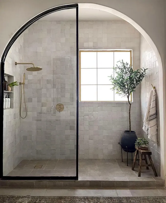 Kemerli duş girişi ve çıtalı pencere, küçük bir iç ağaç ve doğal dokularla spa havasında sıcak bir ortam yaratıyor.