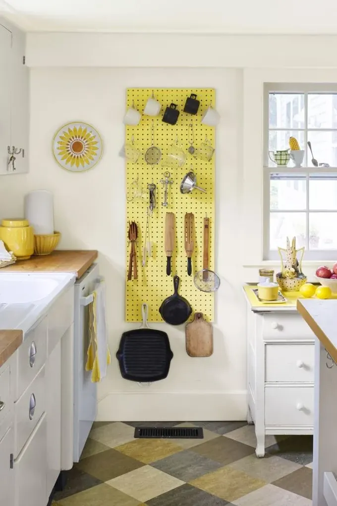 Cesur sarı pegboard, mutfağa renk katıyor ve diğer sarı öğelerle uyum sağlıyor.