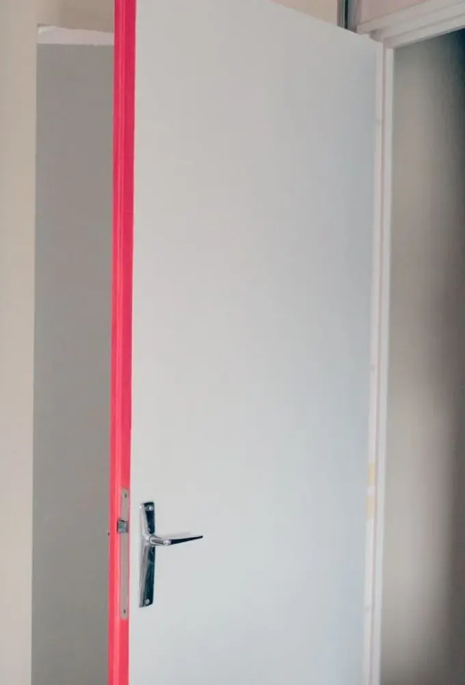Parlak pembe kapı yanı, tamamen nötr alanda renkli ve şık bir dokunuş.