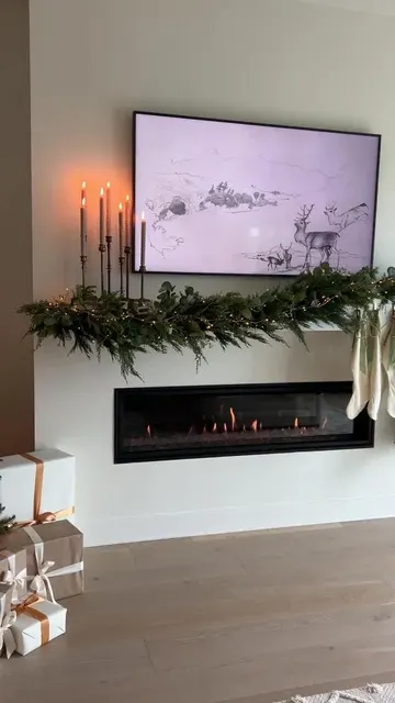 Dokulu yeşil ve yapraklı bir garland, ışıklar, beyaz çoraplar ve vintage şamdanlarla yenileniyor.