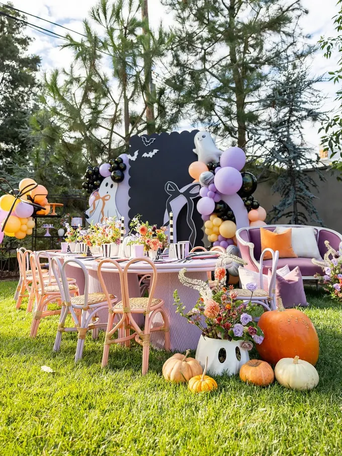 Pembe sandalyeler, hayalet balonlar ve kabaklarla pastel temalı bu bahçe neşeli ve masalsı bir hava veriyor. Cadılar Bayramı her zaman korkutucu olmak zorunda değil, renkli ve tatlı olabilir..