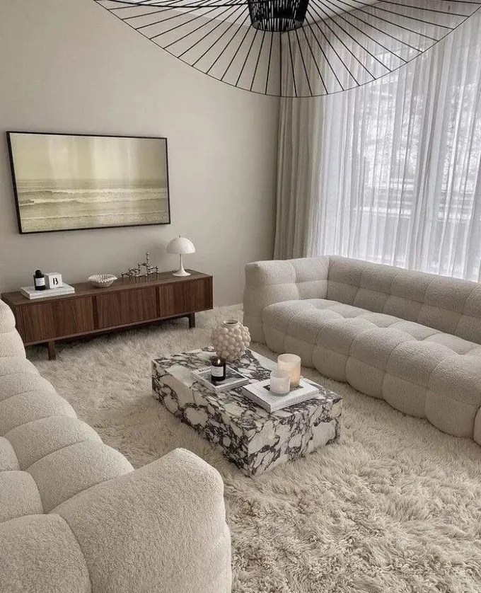 Bukle, suni kürk, mermer ve lekeli ahşap; etkileyici bir minimalist alanın formülü.