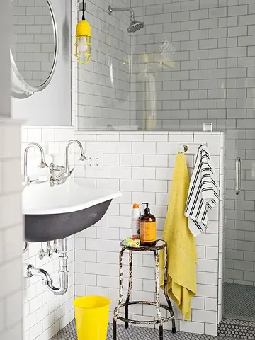 Beyaz metro fayanslı orta yüzyıl modern banyo, yarım duvar, vintage lavabo ve sarı dokunuşlarla daha parlak.