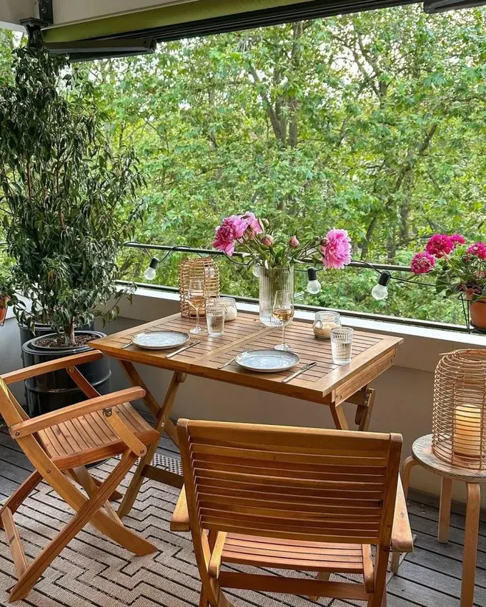 Balkon, katlanabilir serin tonlarda boyanmış tahta mobilyalarla dizayn edilmiş. Işıklar ve saksıdaki ağaçlar hoş bir atmosfer yaratıyor.