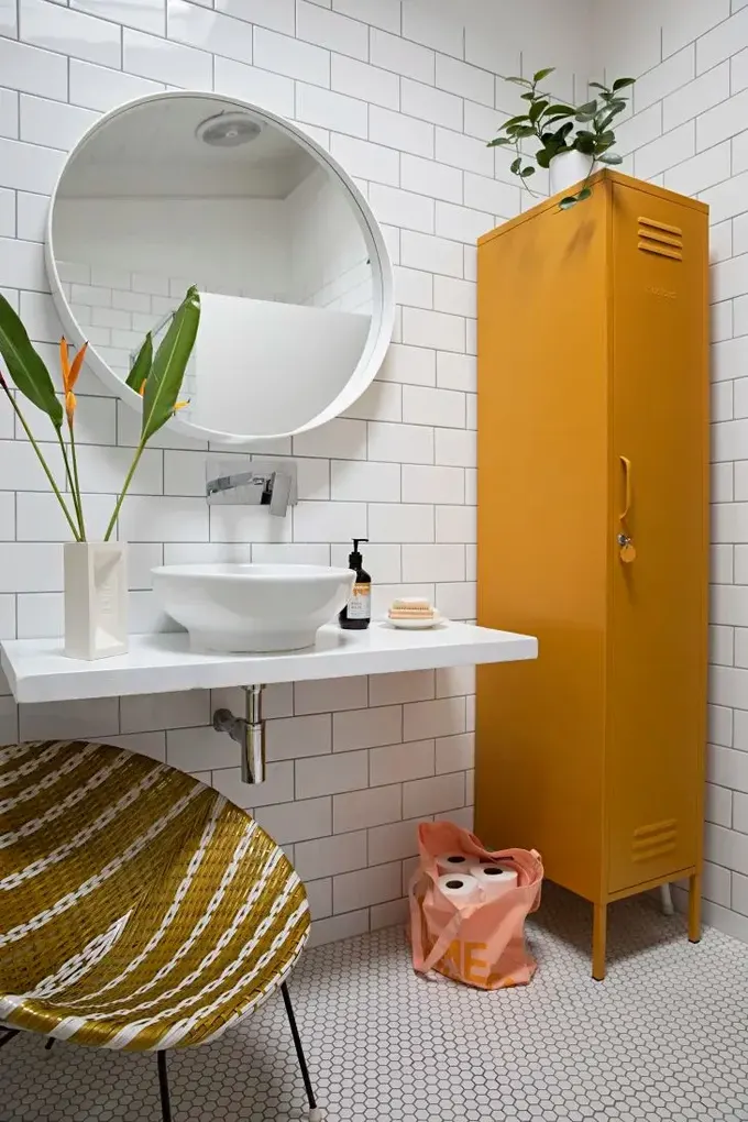 Bu banyo, hardal rengi sandalye ve dolap ile canlandırılmış.