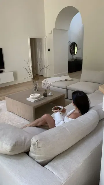 Zarif alan, krem beyaz U şeklinde koltuk, cilalı masa ve TV ünitesiyle saf şık minimalizm sunuyor.