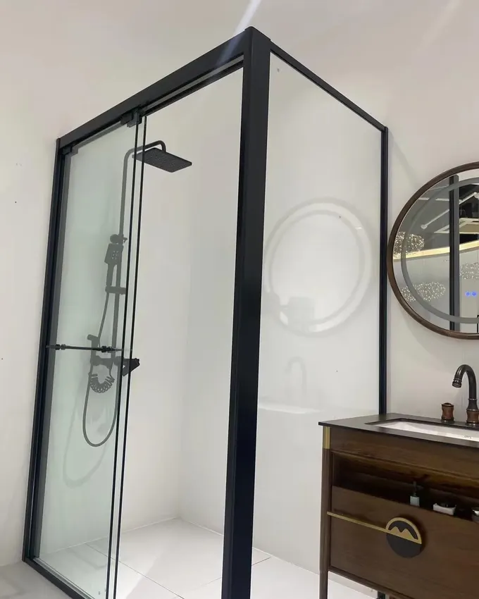 Mat siyah donanımlı modern duş kabini, cama cesur ve endüstriyel bir görünüm veriyor. Minimalist tasarım, yumuşak beyaz duvarlarla güçlü bir mimari kontrast oluşturuyor.