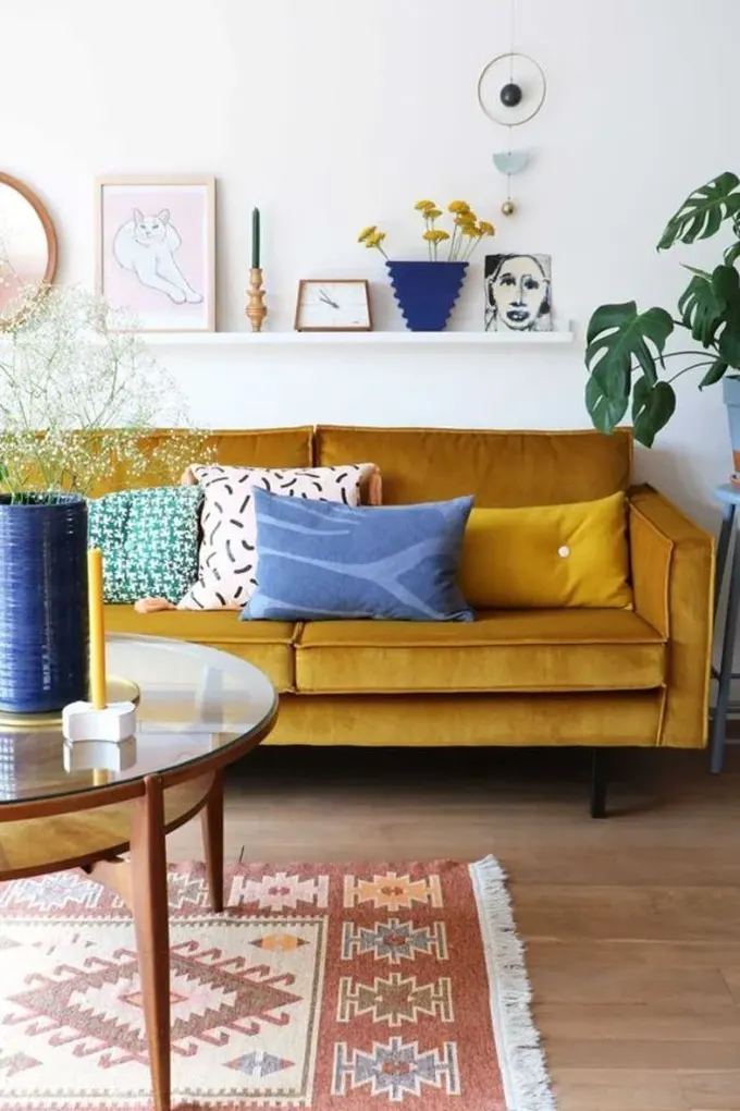 Hardal rengi mid-century modern alanlarda klasik, lacivert ve mavi detaylar ise güçlü bir zıtlık yaratıyor.