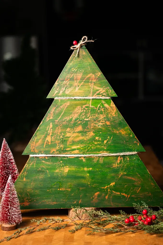 Eskitilmiş rustik Noel ağacı ile vintage bir hava katın. Eskimiş görünüm, doğal ip ve keten kumaş gibi öğelerle harika uyum sağlıyor.