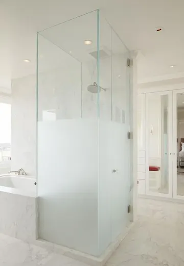 Küvet yanındaki yarı buzlu cam duş bölmesi, şık modern banyo dekorasyon fikri.