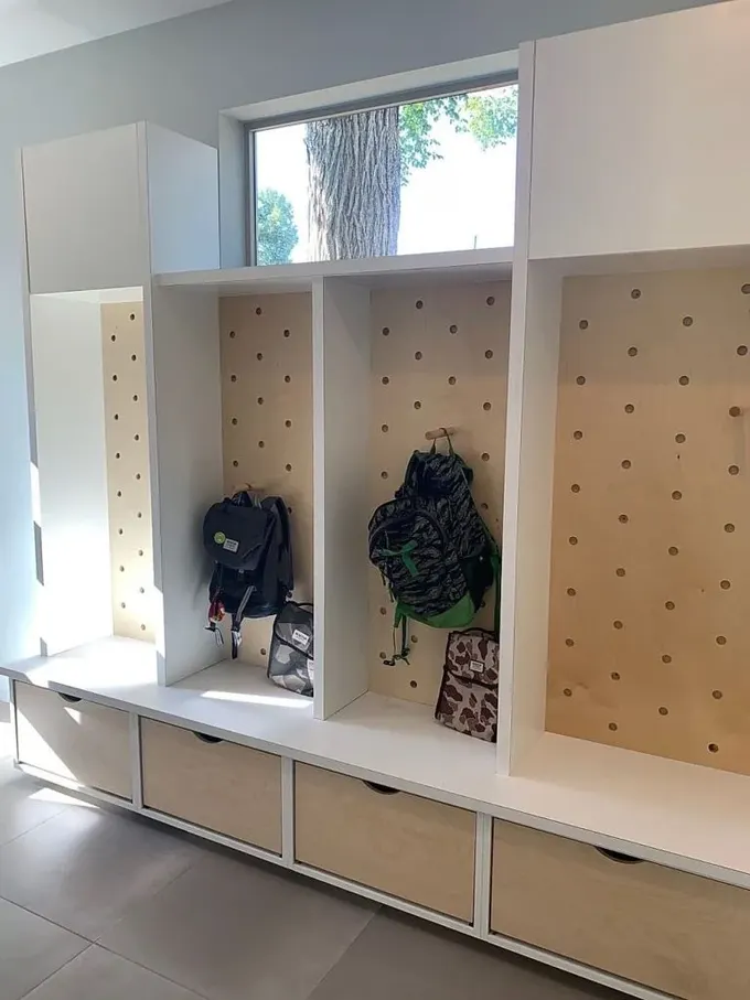Çamurlukta büyük bir depolama ünitesi pegboard ve çekmecelerle oluşturulmuş.