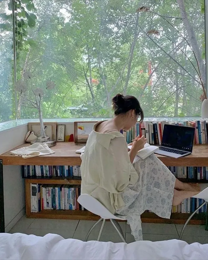 Uzun pencere pervazı ve kitaplık bulunan panoramik pencere tasarımı.