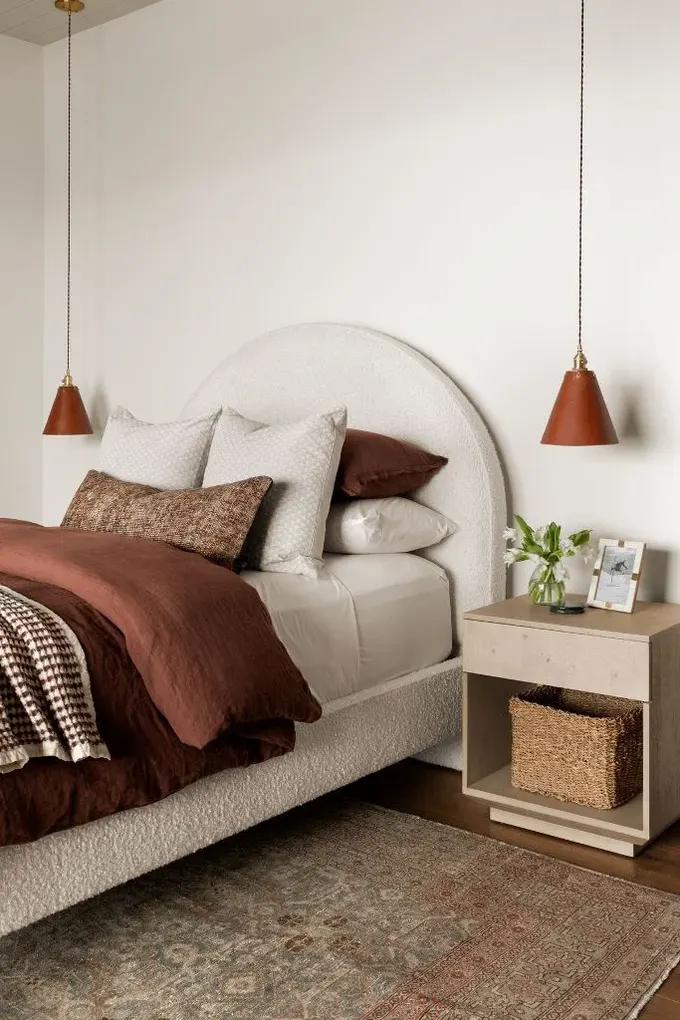 Beyaz yatak odası, terakota, kahverengi ve pas renkleriyle yumuşak bir kontrast yaratılmış.
