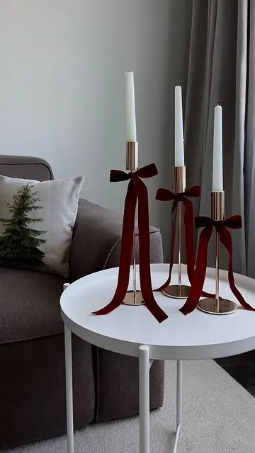 Kırmızı kadife fiyonklarla mumlukları stilize ederek kahve masasını şık, göz alıcı ve zarif yapın.
