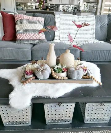 Ahşap boncuklar, doğal ve kumaş balkabakları ile vazolarda kırmızı sonbahar yaprakları, ahşap tepside.