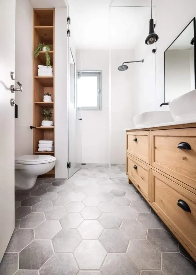 Duşun yanındaki niş, lavabo ile uyumlu boyalı raflarla tasarlanmış.