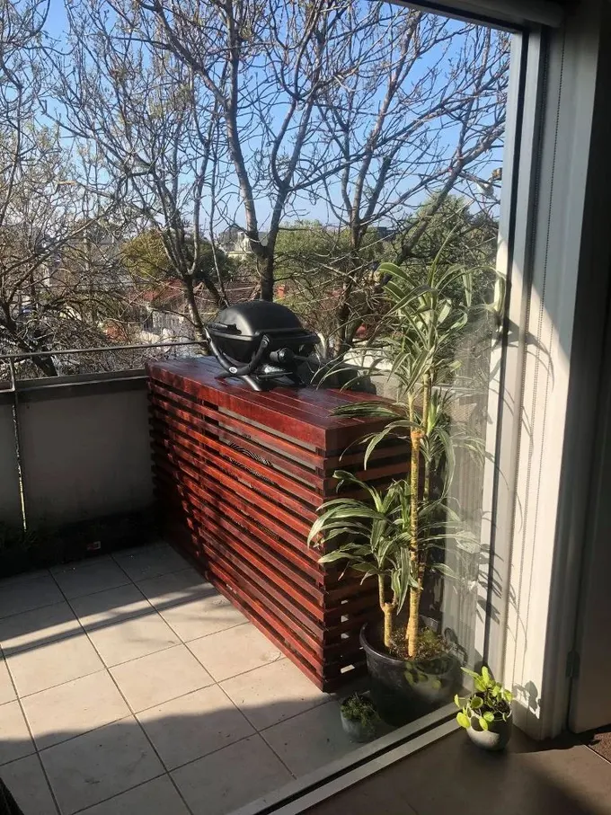 Cesur renkli boyalı konsol masa, çift işlevli olarak klima ünitesini gizliyor.