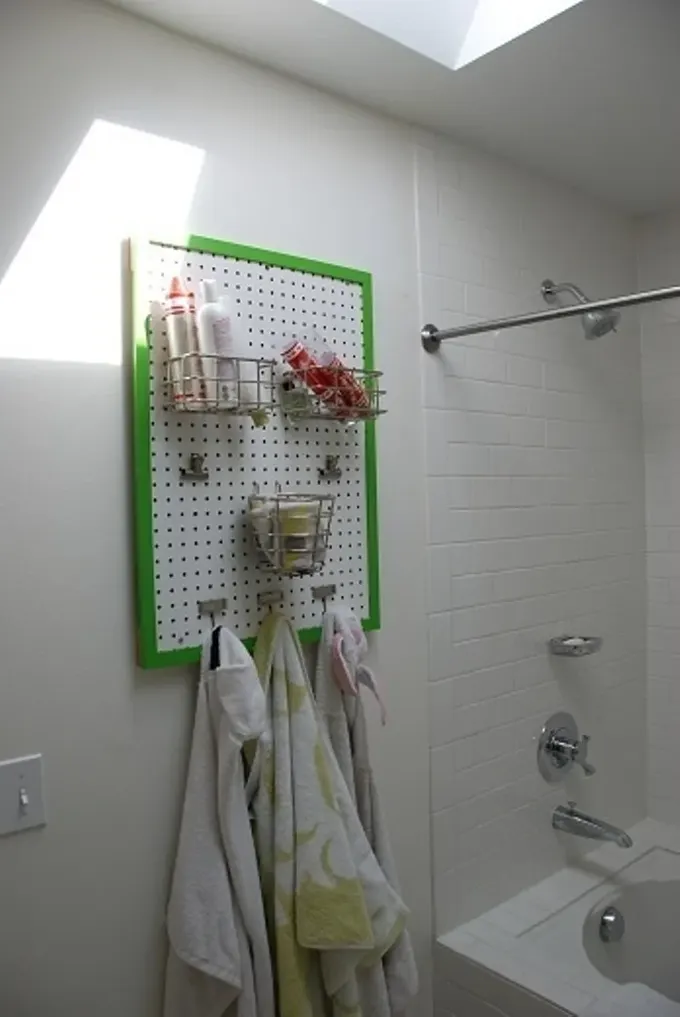 Bu pegboard banyo için pratik bir düzenleyici ve yeşil çerçevesi mekana renk katıyor.