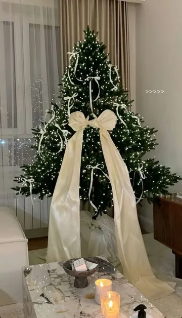 Ağaç, ışıklar, küçük şampanya renkli kurdeleler ve büyük bir kurdele ile çok şık görünüyor.