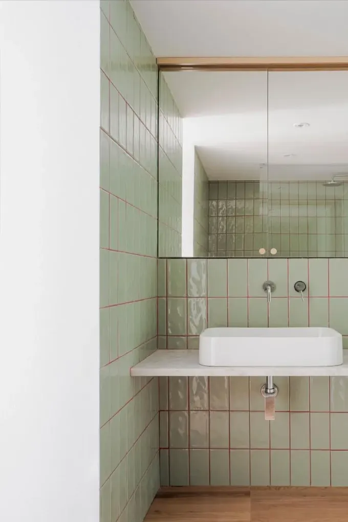 Adaçayı yeşili fayanslar, onları öne çıkarmak için kırmızı derzle eşleştirilmiş.