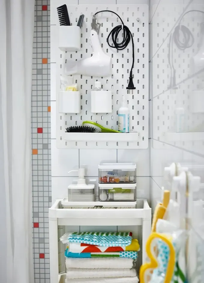 Raflı ve kutulu pegboard, küçük banyoyu köşe duvara takarak daha düzenli hale getirir.