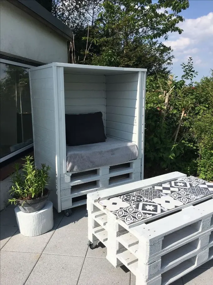 Küçük bir palet pergola ile uyumlu palet masanın mükemmel kombini, tekerleklerle hareket kolaylığı sağlanmış.