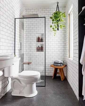 Modern banyo; küçük mozaik ve metro karolar, gömme raflar, lavabo ve ahşap tabure ile fonksiyonel alan.
