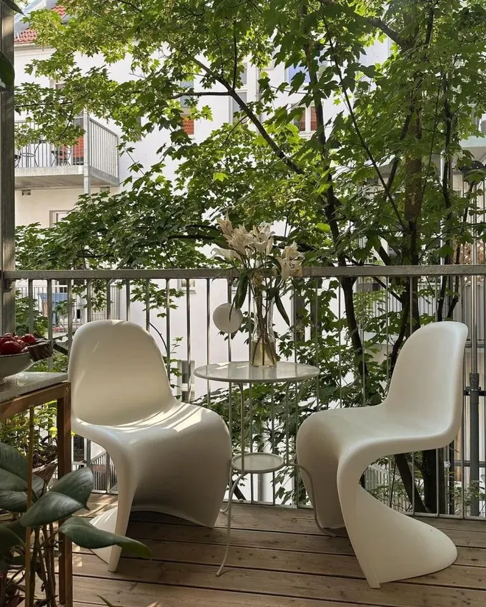 Modern balkon, çok katlı mini masa ve beyaz plastik sandalyelerle ilgi çekici, plastik dayanıklı ve dış mekan için ideal.